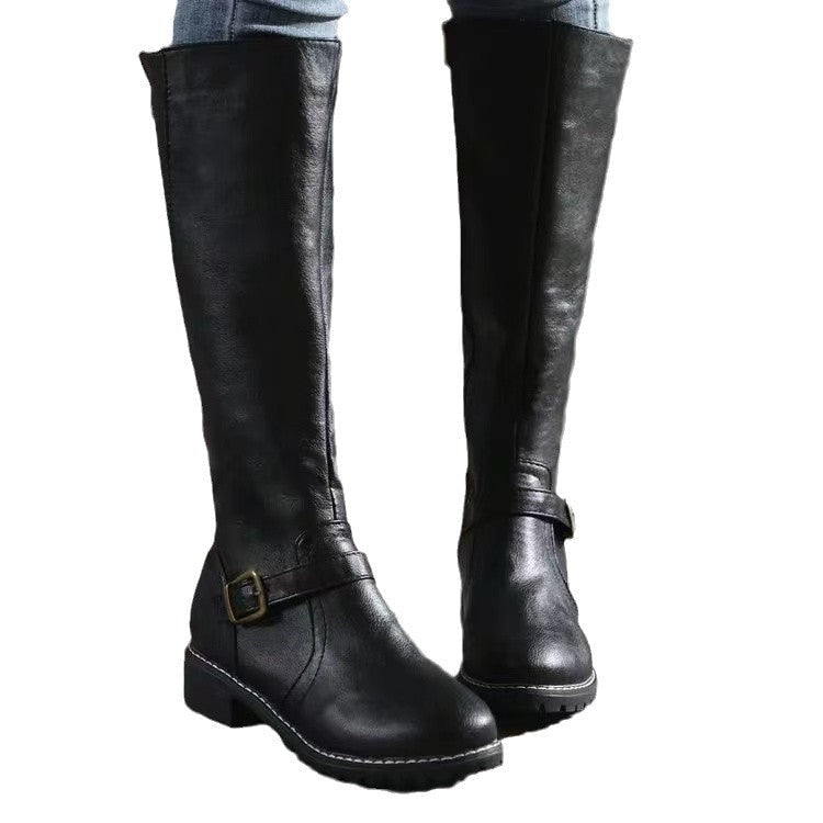 Black knee-high boots displayed against a white background, showing the contrasting sole edges, ankle buckles, and low heels.