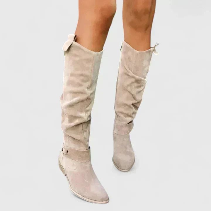 Woman wearing knee-high slouchy boots with a block heel and side zipper detail, styled outdoors on pavement._3