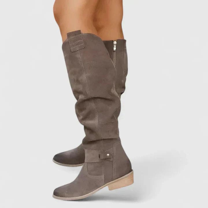 Woman wearing knee-high slouchy boots with a block heel and side zipper detail, styled outdoors on pavement._4