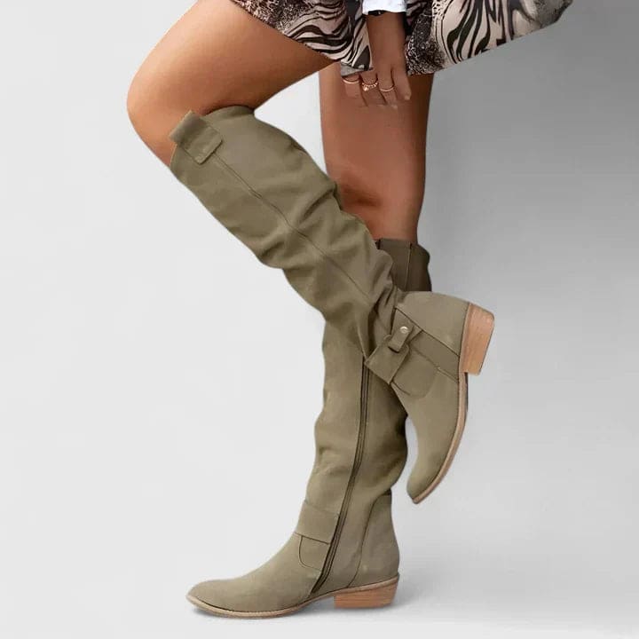 Woman wearing knee-high slouchy boots with a block heel and side zipper detail, styled outdoors on pavement._8