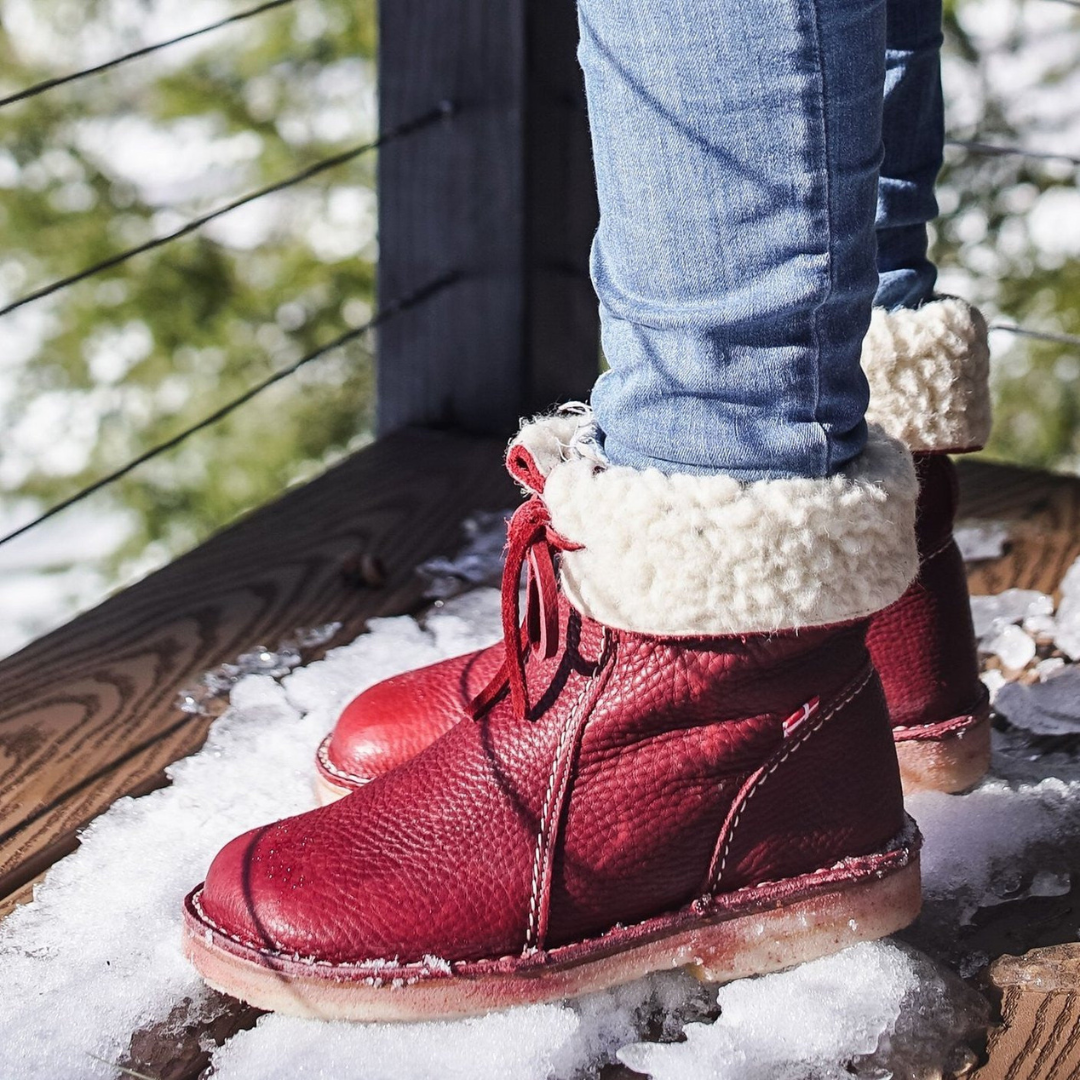 A mid-calf boot in dark grey with a textured upper, lace-up detail at the top, contrast stitching, and a light-colored cushioned sole._9