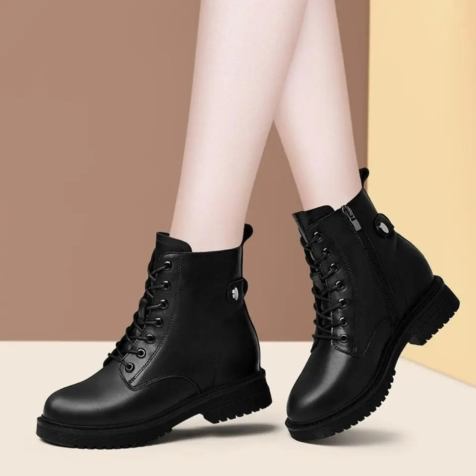 Pair of black ankle boots viewed from the opposite side, emphasizing the side zippers, ankle-height shafts, sturdy low heels, and textured outsoles.