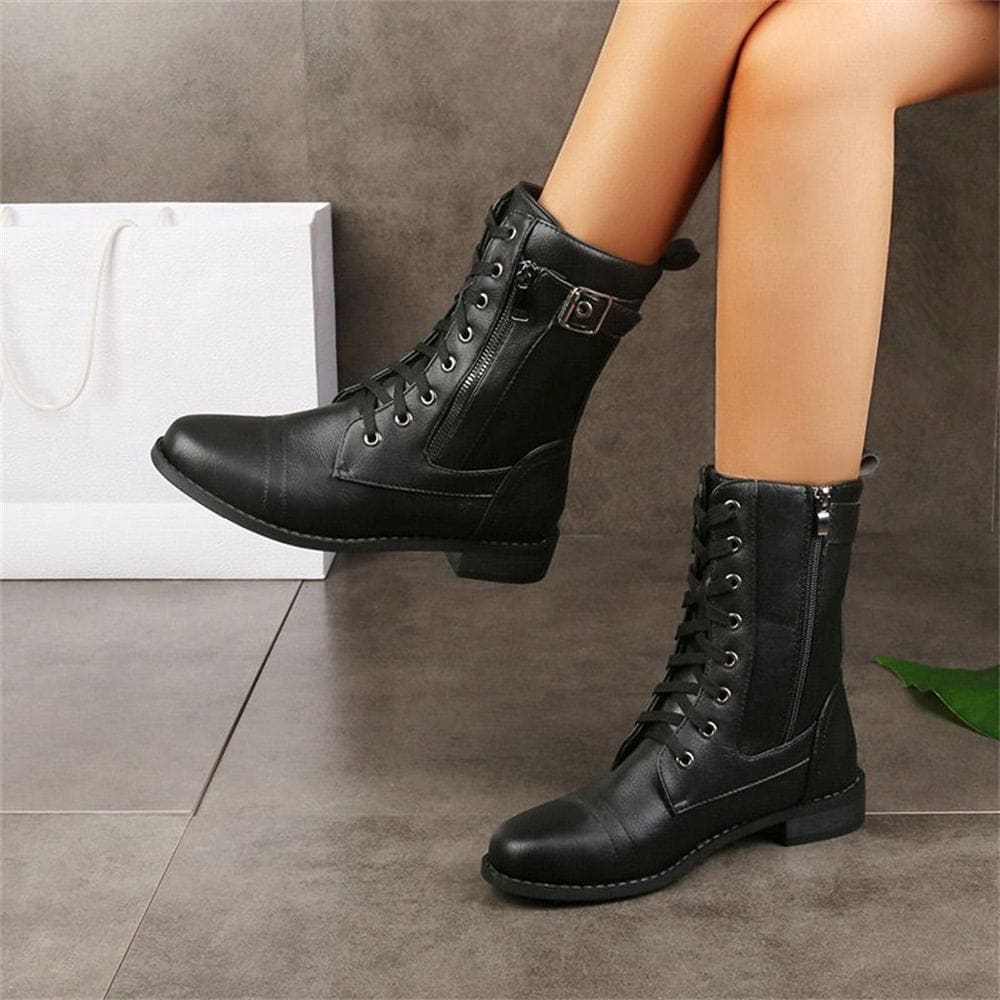 Woman wearing mid-calf combat boots with lace-up front, side zipper, buckle detail, and low block heel_0