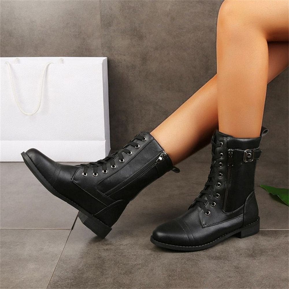 Woman wearing mid-calf combat boots with lace-up front, side zipper, buckle detail, and low block heel_1