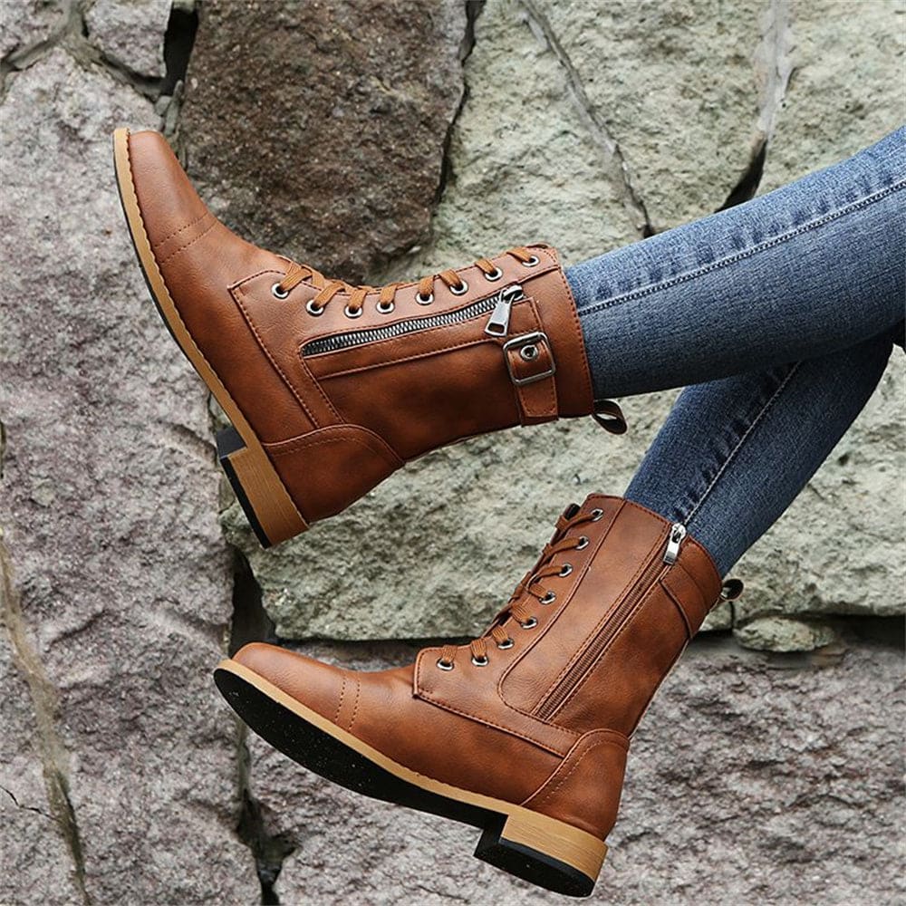 Woman wearing mid-calf combat boots with lace-up front, side zipper, buckle detail, and low block heel_11