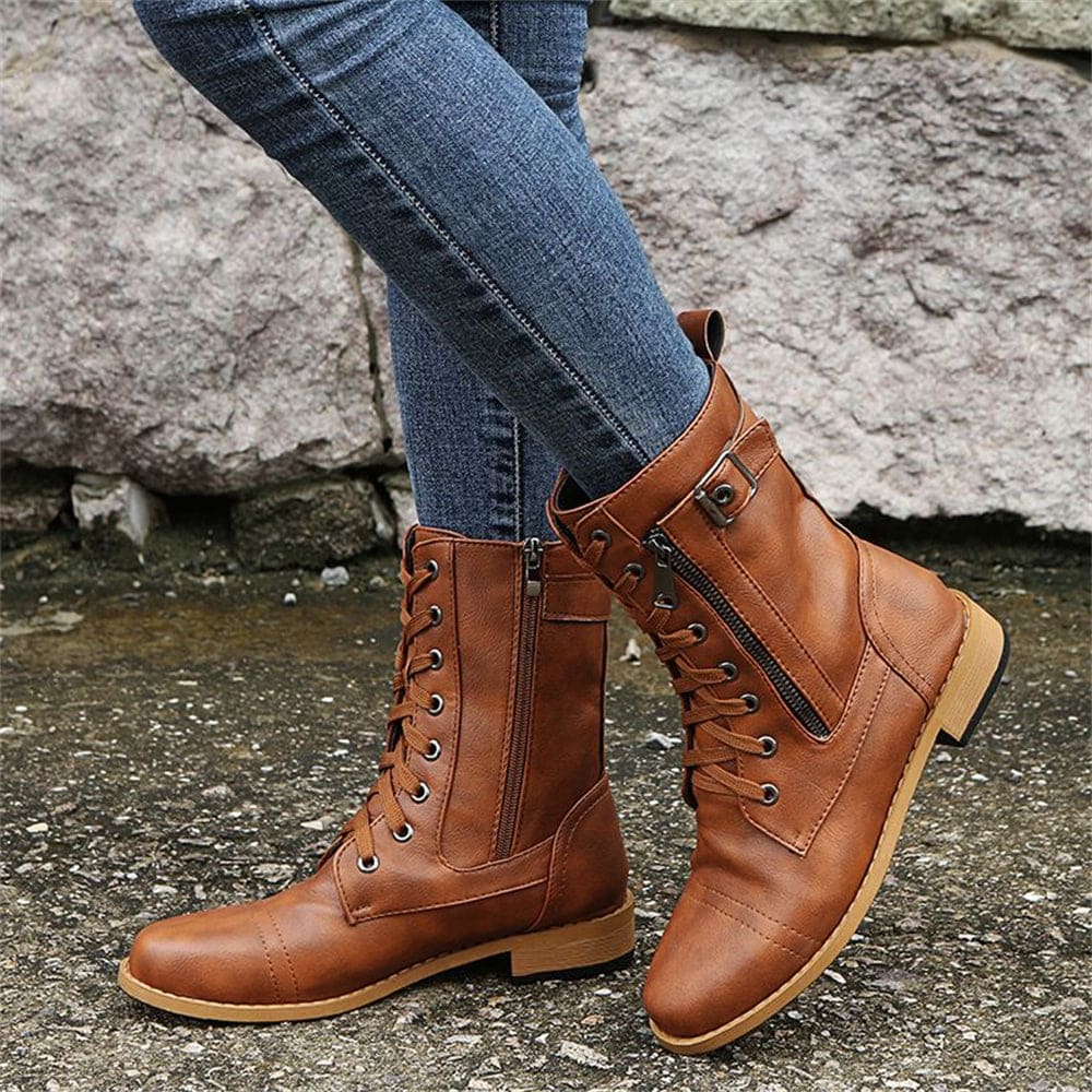 Woman wearing mid-calf combat boots with lace-up front, side zipper, buckle detail, and low block heel_13