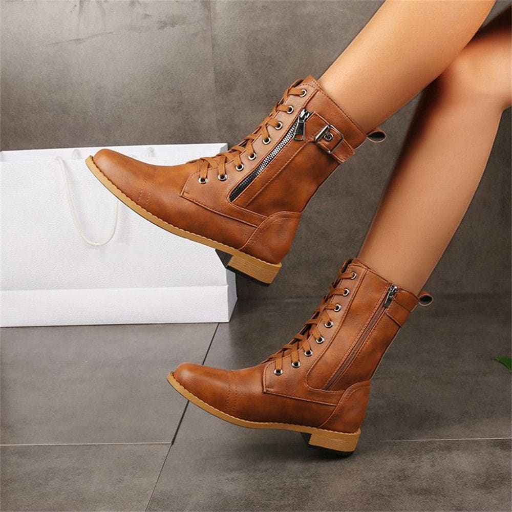 Woman wearing mid-calf combat boots with lace-up front, side zipper, buckle detail, and low block heel_14