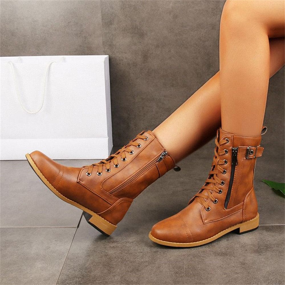 Woman wearing mid-calf combat boots with lace-up front, side zipper, buckle detail, and low block heel_16