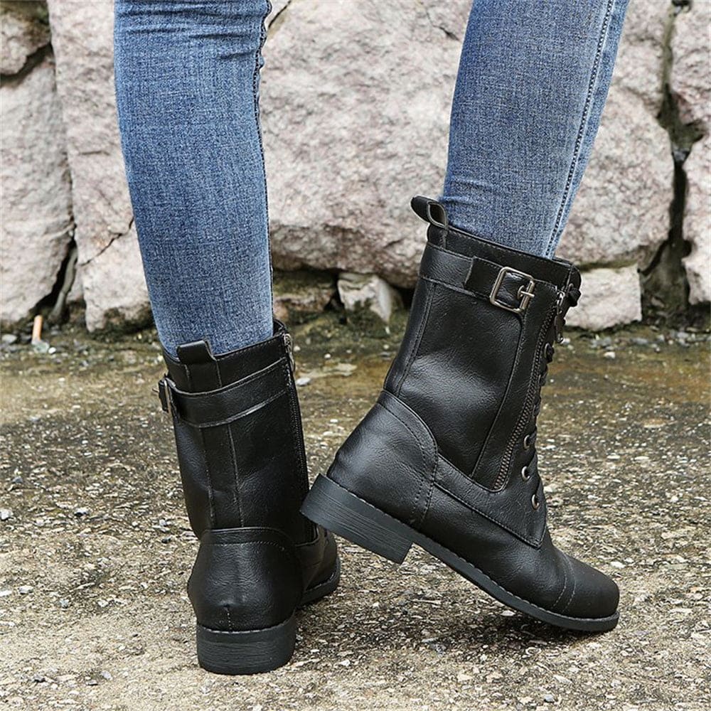 Woman wearing mid-calf combat boots with lace-up front, side zipper, buckle detail, and low block heel_4