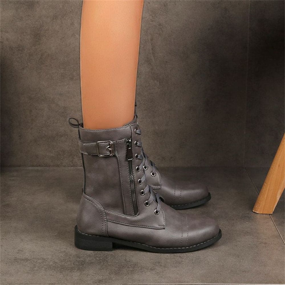 Woman wearing mid-calf combat boots with lace-up front, side zipper, buckle detail, and low block heel_6