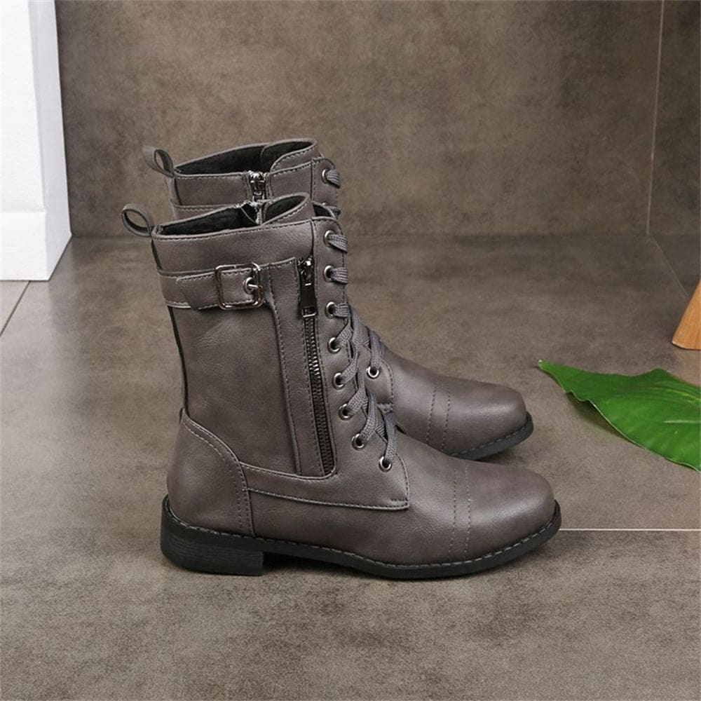 Woman wearing mid-calf combat boots with lace-up front, side zipper, buckle detail, and low block heel_7