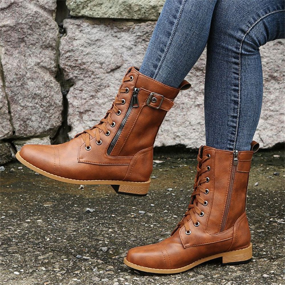 Woman wearing mid-calf combat boots with lace-up front, side zipper, buckle detail, and low block heel_9