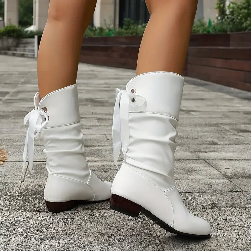 White lace-up slouch boots viewed from behind and the side, highlighting their low block heels.