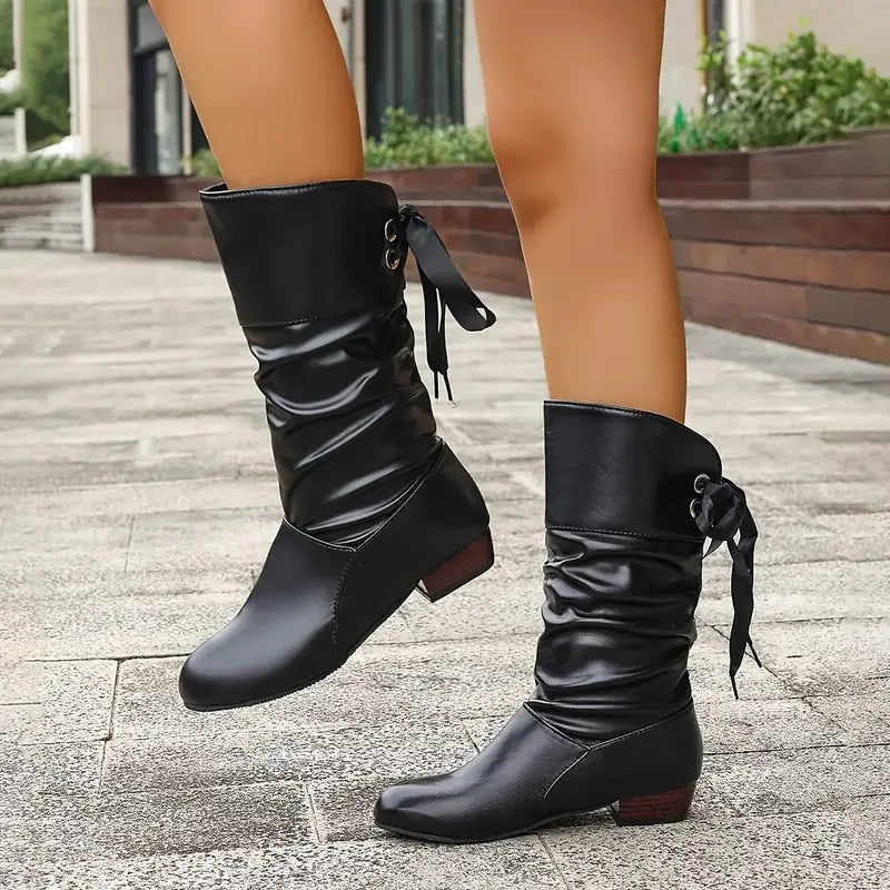 Black lace-up slouch calf boots shown in a staggered standing pose with low block heels.