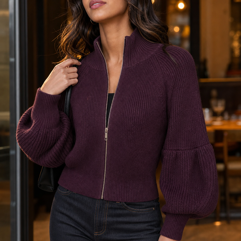 Close view of the burgundy cropped zip-up cardigan with a raised collar and voluminous lantern sleeves, styled with dark jeans.