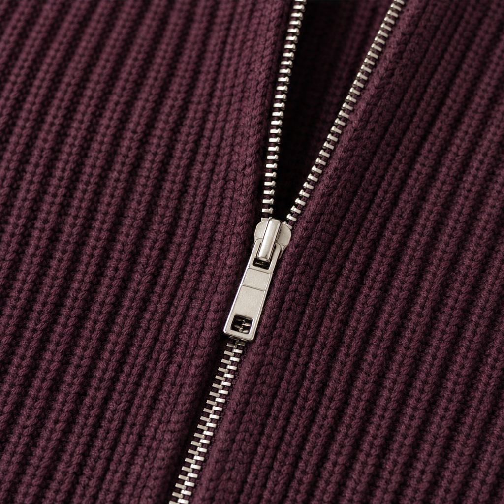 Close-up of the silver front zipper set into the burgundy ribbed knit cardigan.