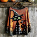 Orange knitted sweater on a wooden hanger with a black cat wearing a striped witch hat, green eyes, striped legs and a curling tail, hung against weathered wood boards with pumpkins above._0