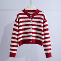 A striped cropped cardigan with a round neckline, button front, long sleeves, and ribbed trim hangs on a hanger._0
