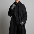 Woman wearing a long black coat with wide collar, button front closure, and relaxed fit, styled with gloves and a scarf._0