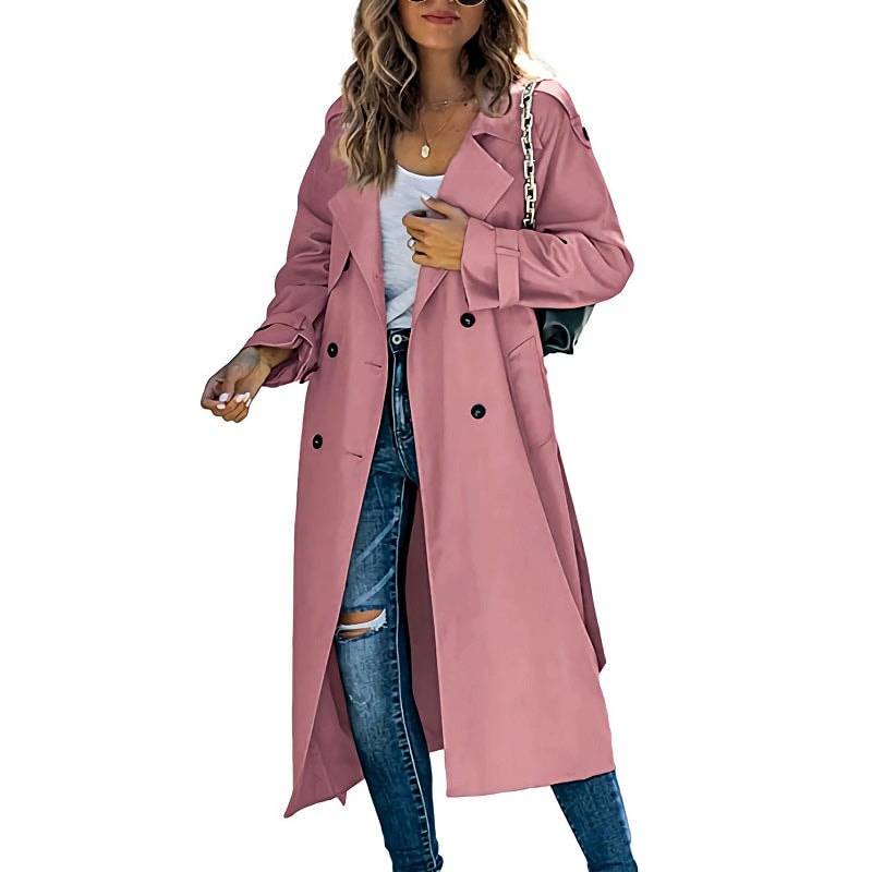 Dusty rose long trench coat featuring a double-breasted front, notched lapels, and belted cuffs over casual jeans.