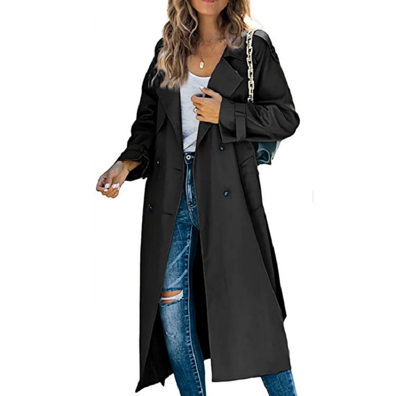 Black long trench coat with a double-breasted button front and belted cuffs, worn open over a white top and blue jeans.