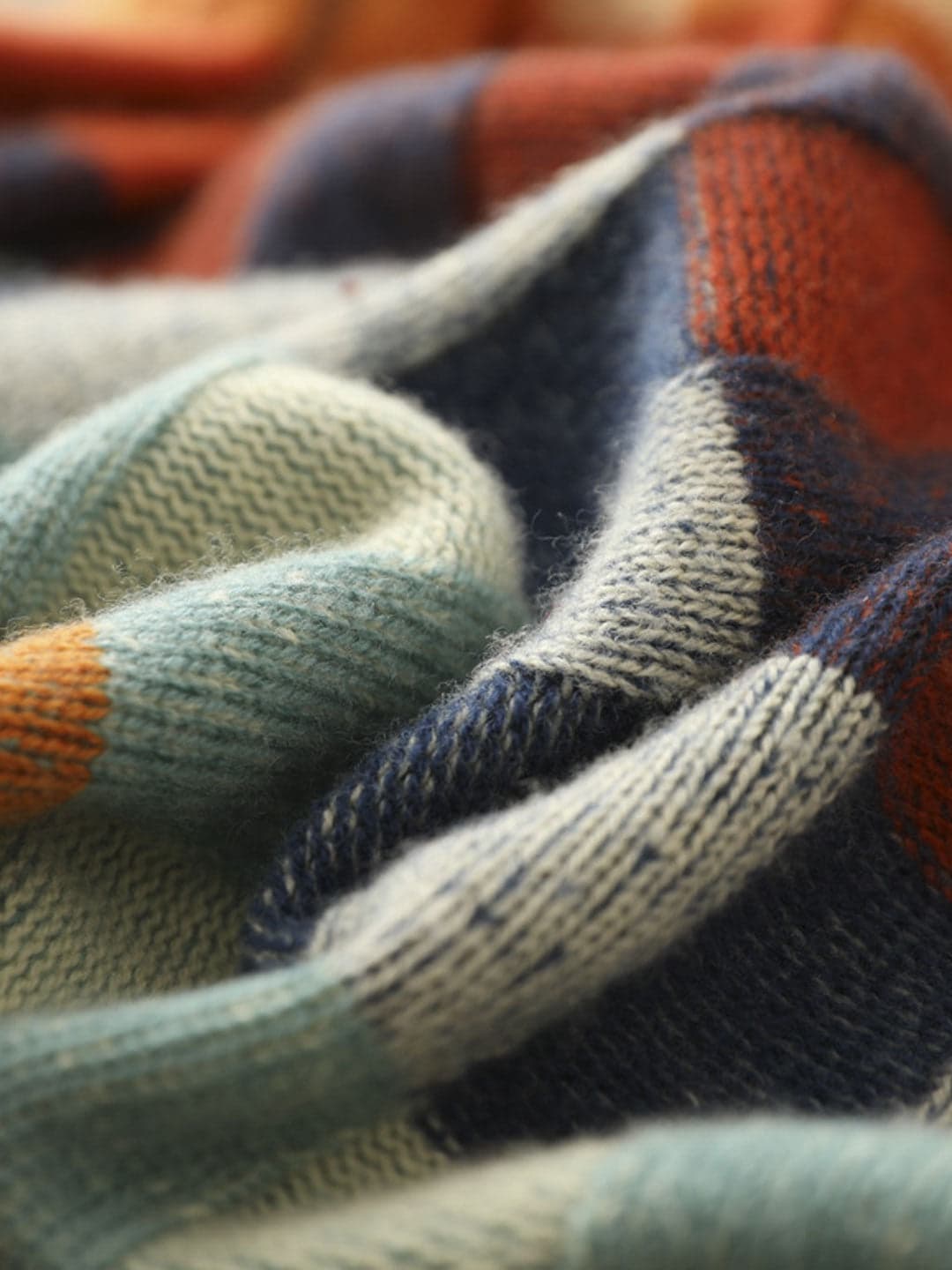 Woman wearing a loose fit turtleneck jumper with a colorblock plaid pattern in shades of orange, teal, navy, and grey._6