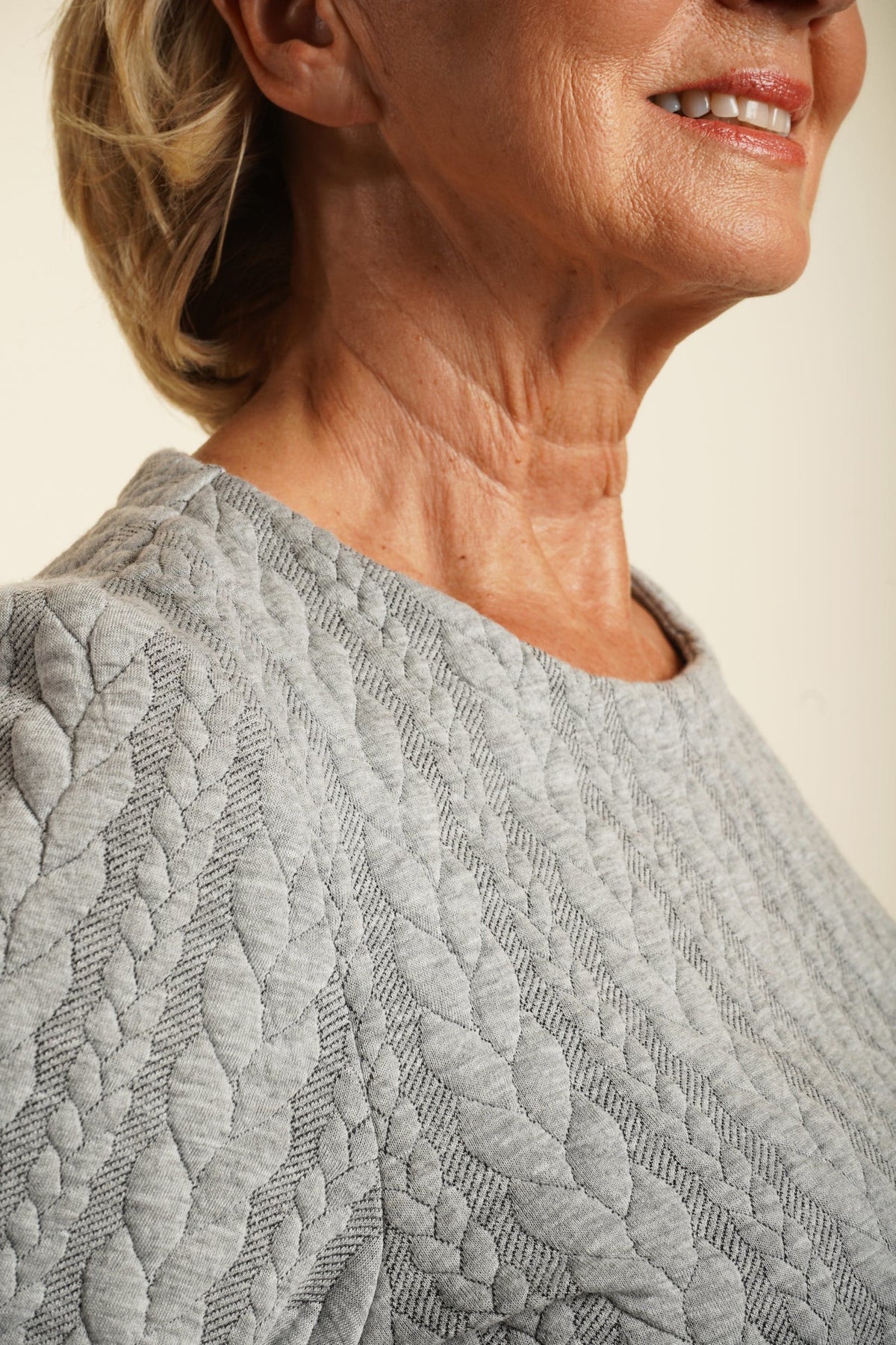 Woman wearing a navy long sleeve top with allover cable texture and a round neckline, with matching navy bottoms, against a plain light background._4