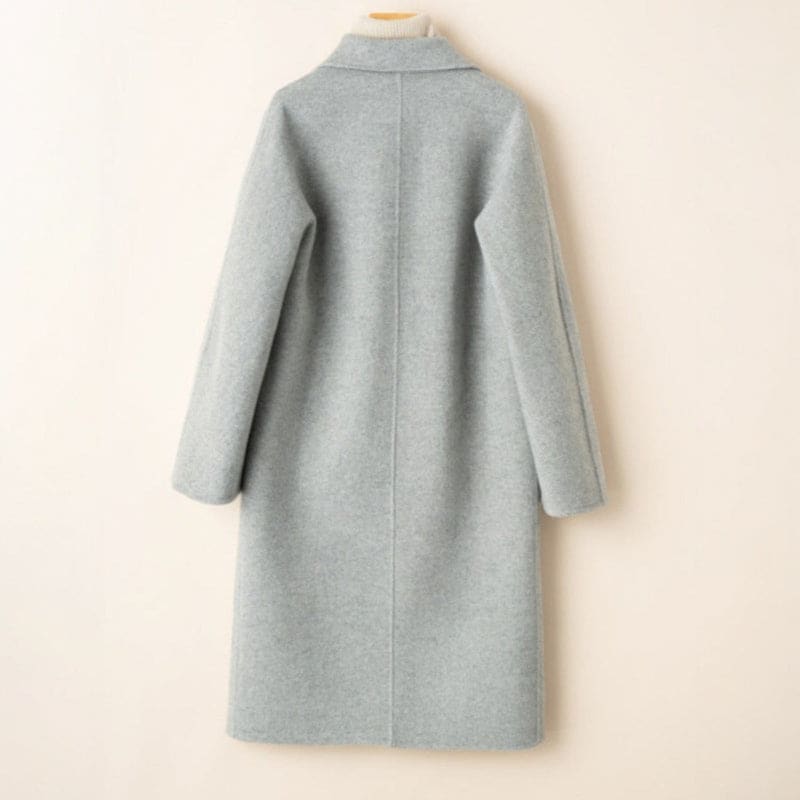 A double breasted longline coat with notched lapels and side welt pockets displayed on a mannequin._2