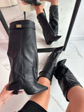 Woman wearing mid-calf boots with pointed toe, block heel, and decorative turnlock hardware at ankle._0