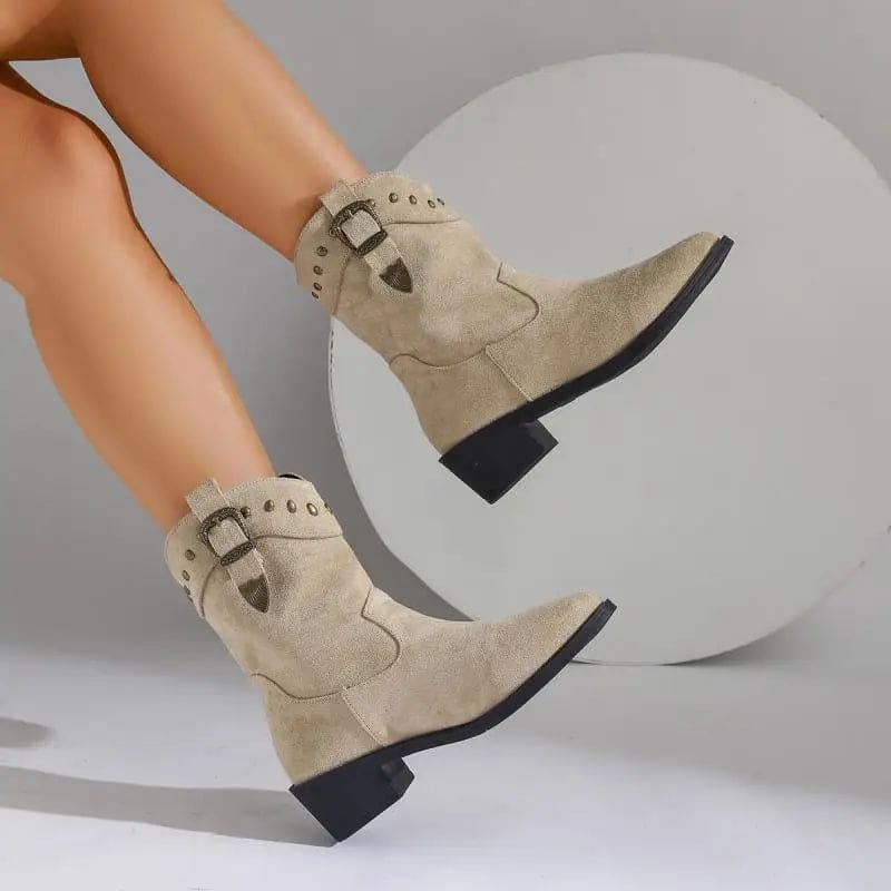 Woman wearing mid-calf boots with buckle strap and stud detailing, paired with bare legs._0