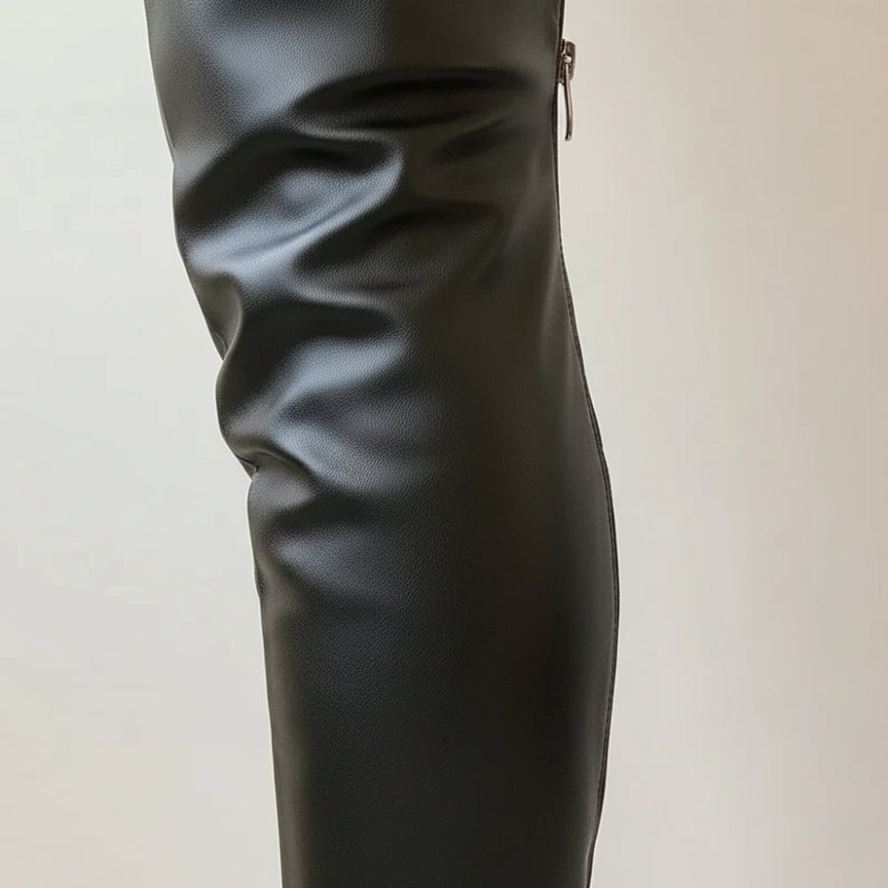 Close-up of the black boot shaft showing its smooth finish, gathered folds, side seam, and zipper pull.