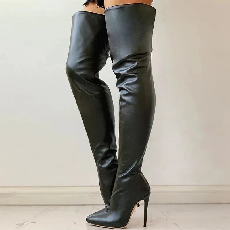Pair of black over-the-knee pointed-toe stiletto boots modeled with crossed legs, showing the tall silhouette and softly gathered shafts.