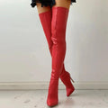 Red over-the-knee pointed-toe stiletto boots modeled with one foot lifted, illustrating the available bold color variation.