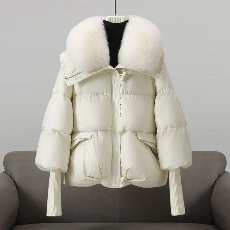 Woman wearing an oversized black puffer jacket with a wide statement collar, styled over a black turtleneck and pants._3