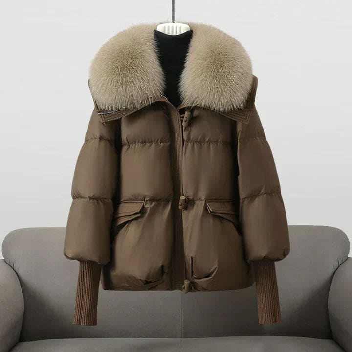 Woman wearing an oversized black puffer jacket with a wide statement collar, styled over a black turtleneck and pants._5