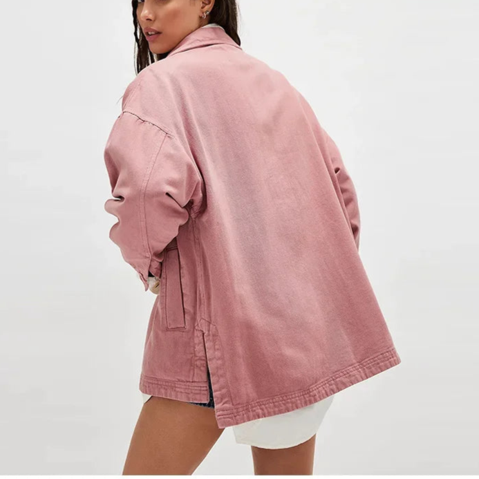 Woman wearing an oversized button-front jacket with chest pockets and a relaxed silhouette, styled over a white top and pants._14