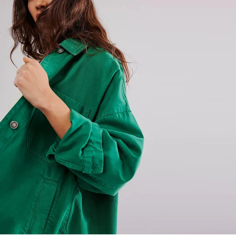 Woman wearing an oversized button-front jacket with chest pockets and a relaxed silhouette, styled over a white top and pants._17