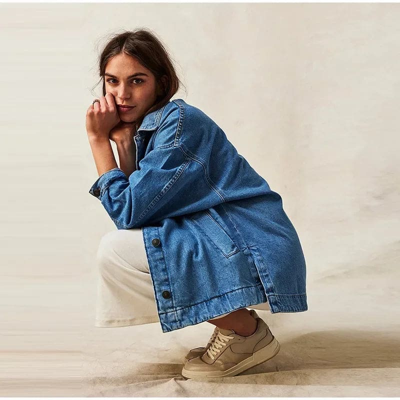 Woman wearing an oversized button-front jacket with chest pockets and a relaxed silhouette, styled over a white top and pants._20
