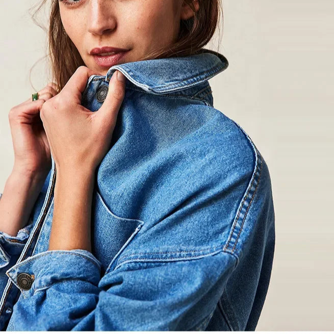 Woman wearing an oversized button-front jacket with chest pockets and a relaxed silhouette, styled over a white top and pants._21