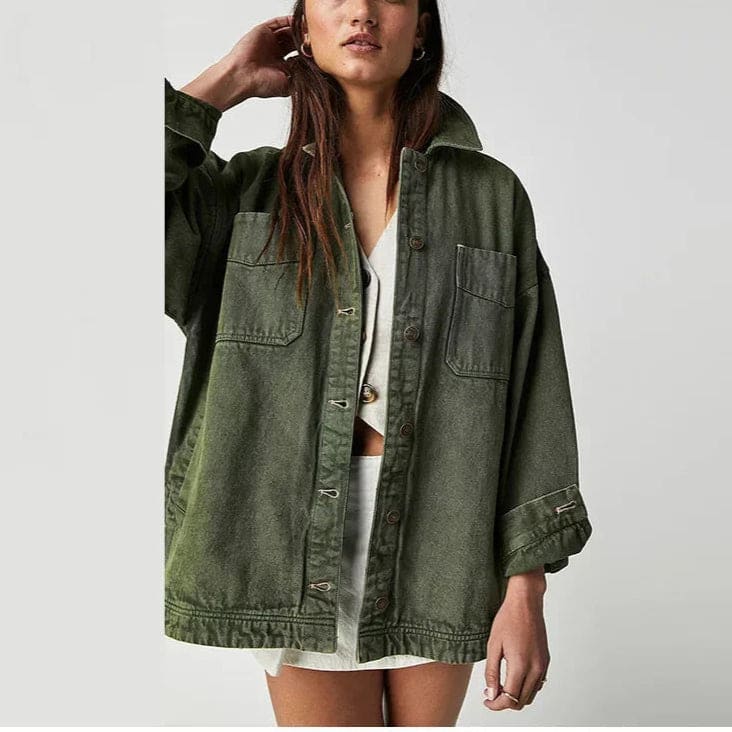 Woman wearing an oversized button-front jacket with chest pockets and a relaxed silhouette, styled over a white top and pants._23