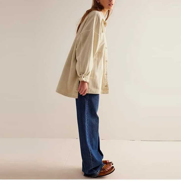 Woman wearing an oversized button-front jacket with chest pockets and a relaxed silhouette, styled over a white top and pants._24