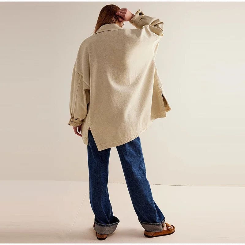 Woman wearing an oversized button-front jacket with chest pockets and a relaxed silhouette, styled over a white top and pants._26
