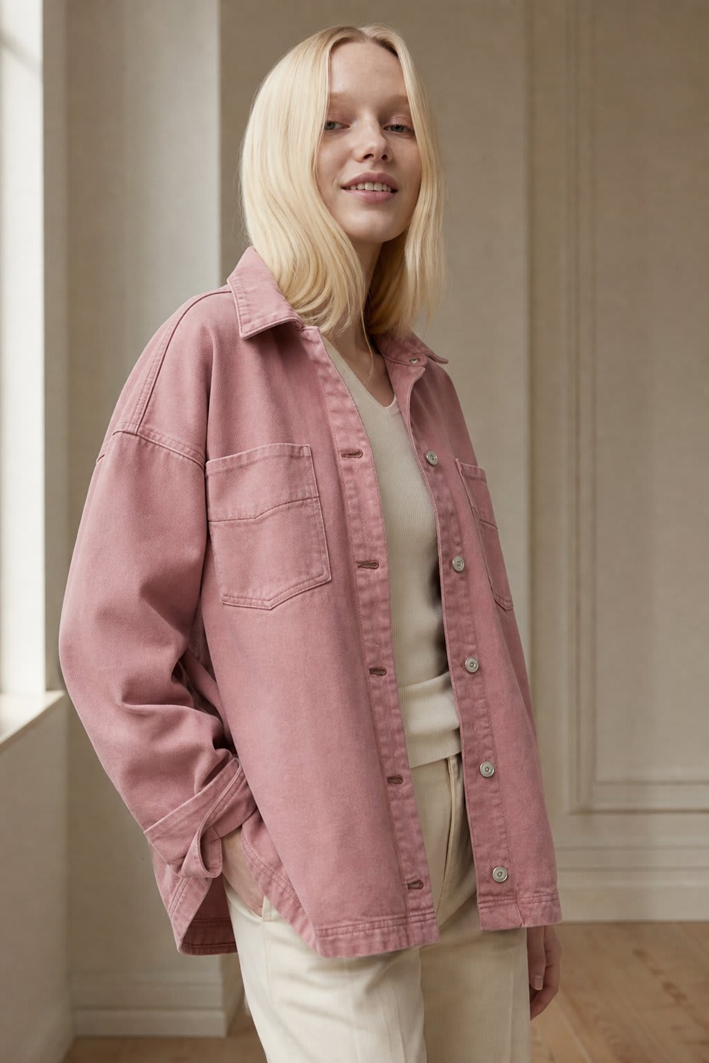 Woman wearing an oversized button-front jacket with chest pockets and a relaxed silhouette, styled over a white top and pants._4