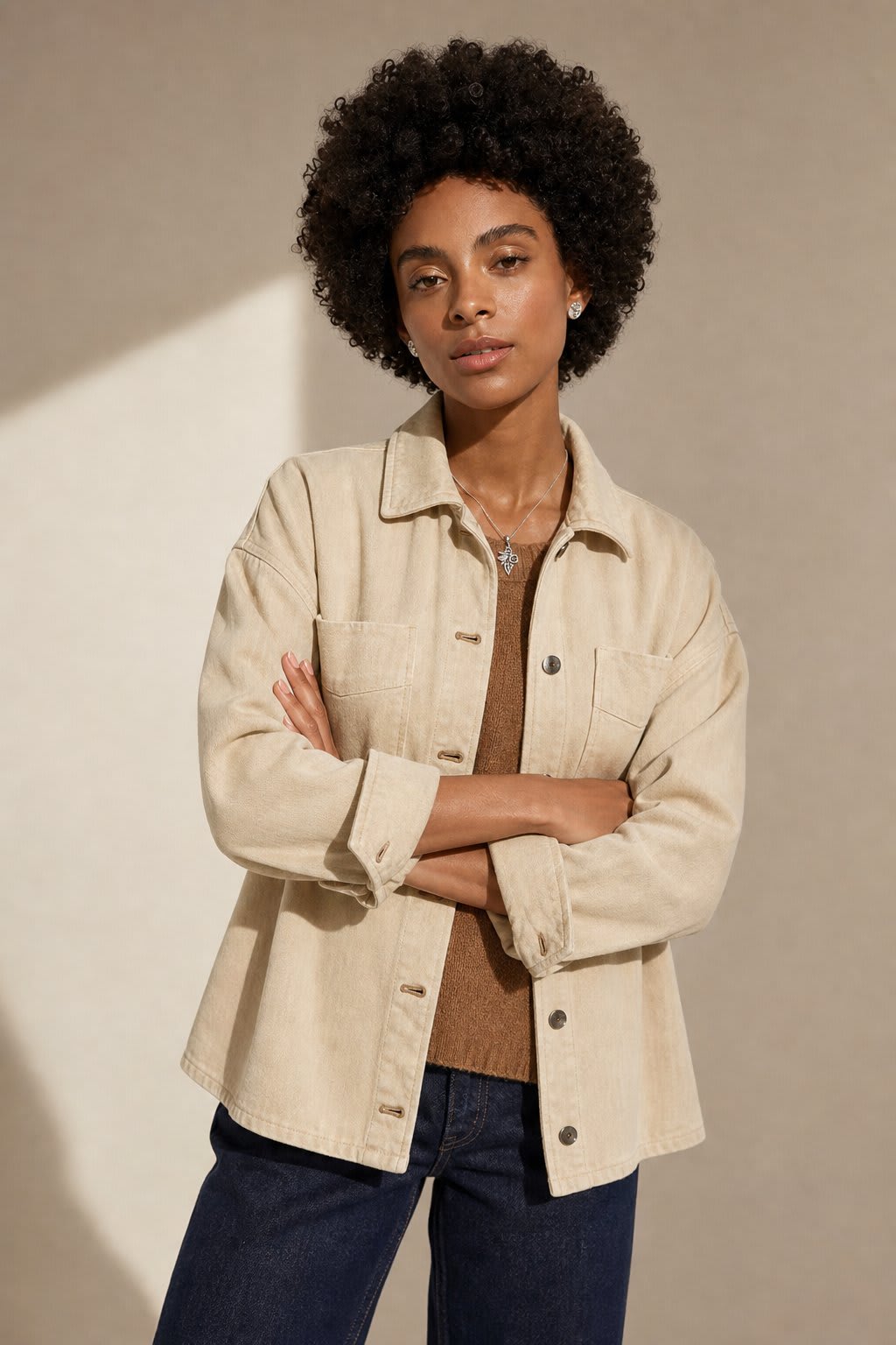 Woman wearing an oversized button-front jacket with chest pockets and a relaxed silhouette, styled over a white top and pants._6