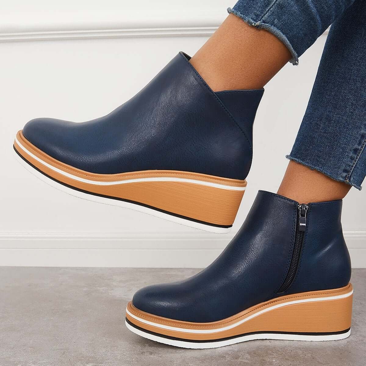Navy blue platform ankle boots in side view, clearly showing the side zipper and raised sole.