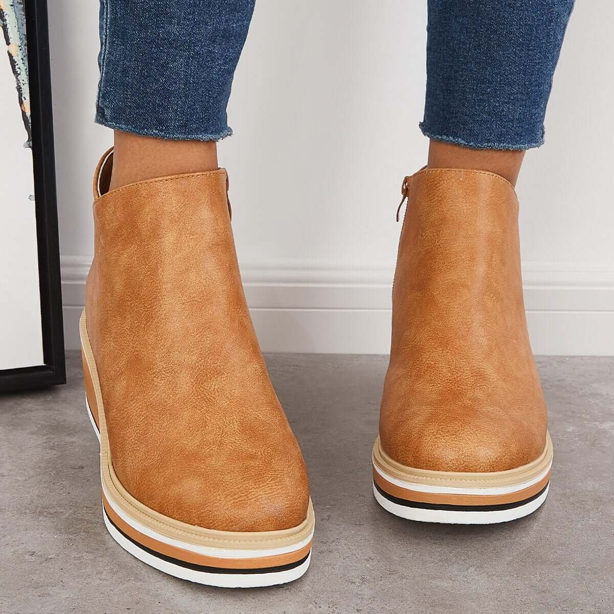 Tan ankle boots shown from the front with rounded toes and layered platform soles.