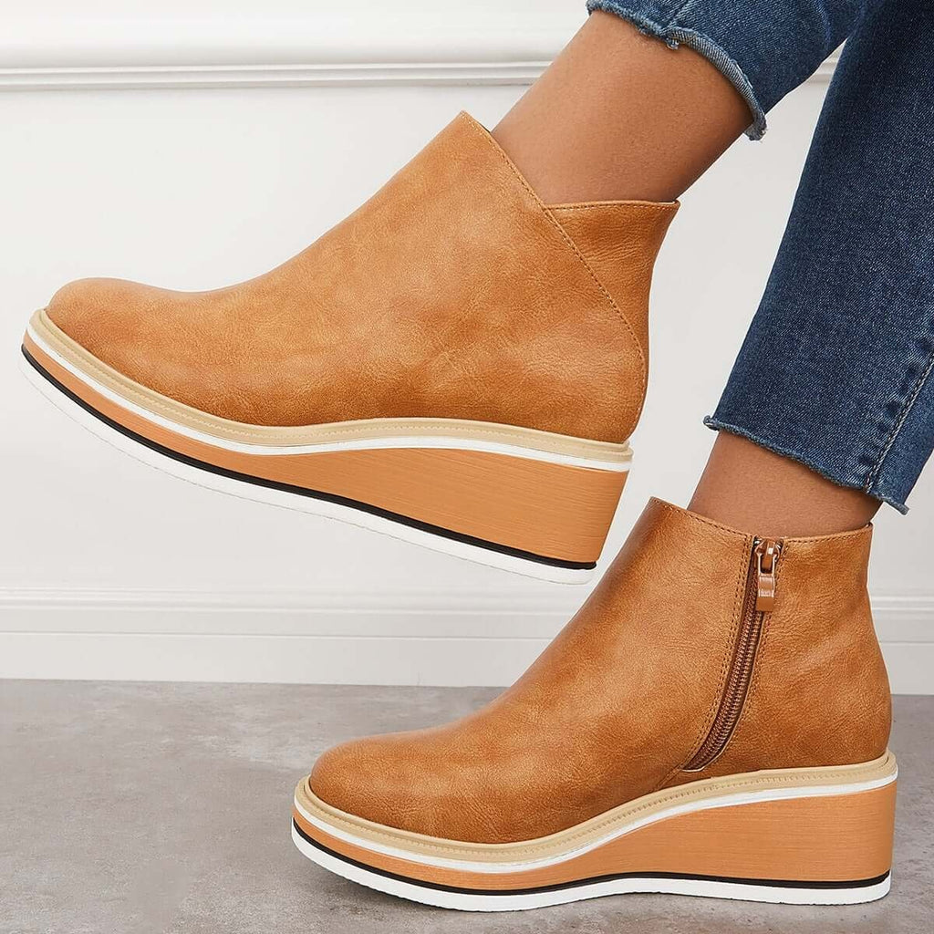 Tan platform ankle boots in side view, showing the side zipper and raised wedge-shaped sole.