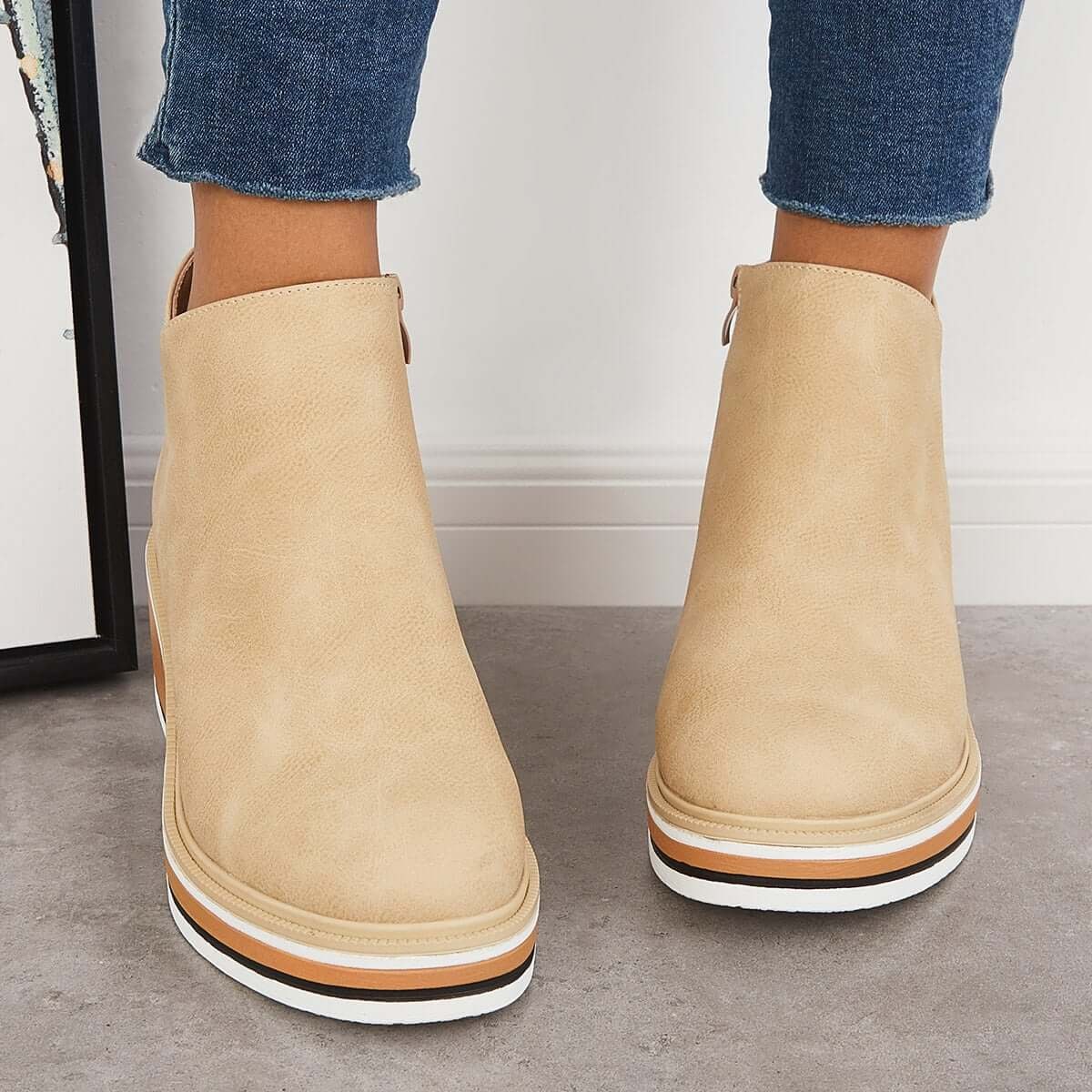 Light beige ankle boots shown from the front with rounded toes and stacked platform soles.