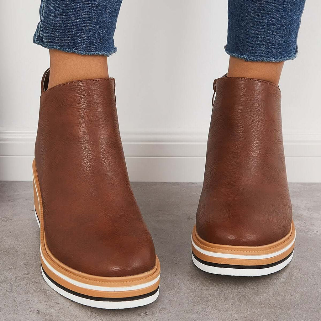 Brown ankle boots shown from the front with rounded toes and layered platform soles.