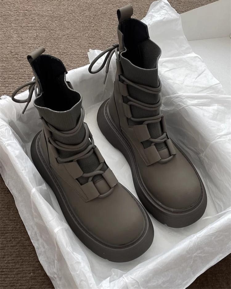 Pair of high-top lace-up platform boots with chunky soles in a neutral tone, displayed on white tissue paper in an open box._1